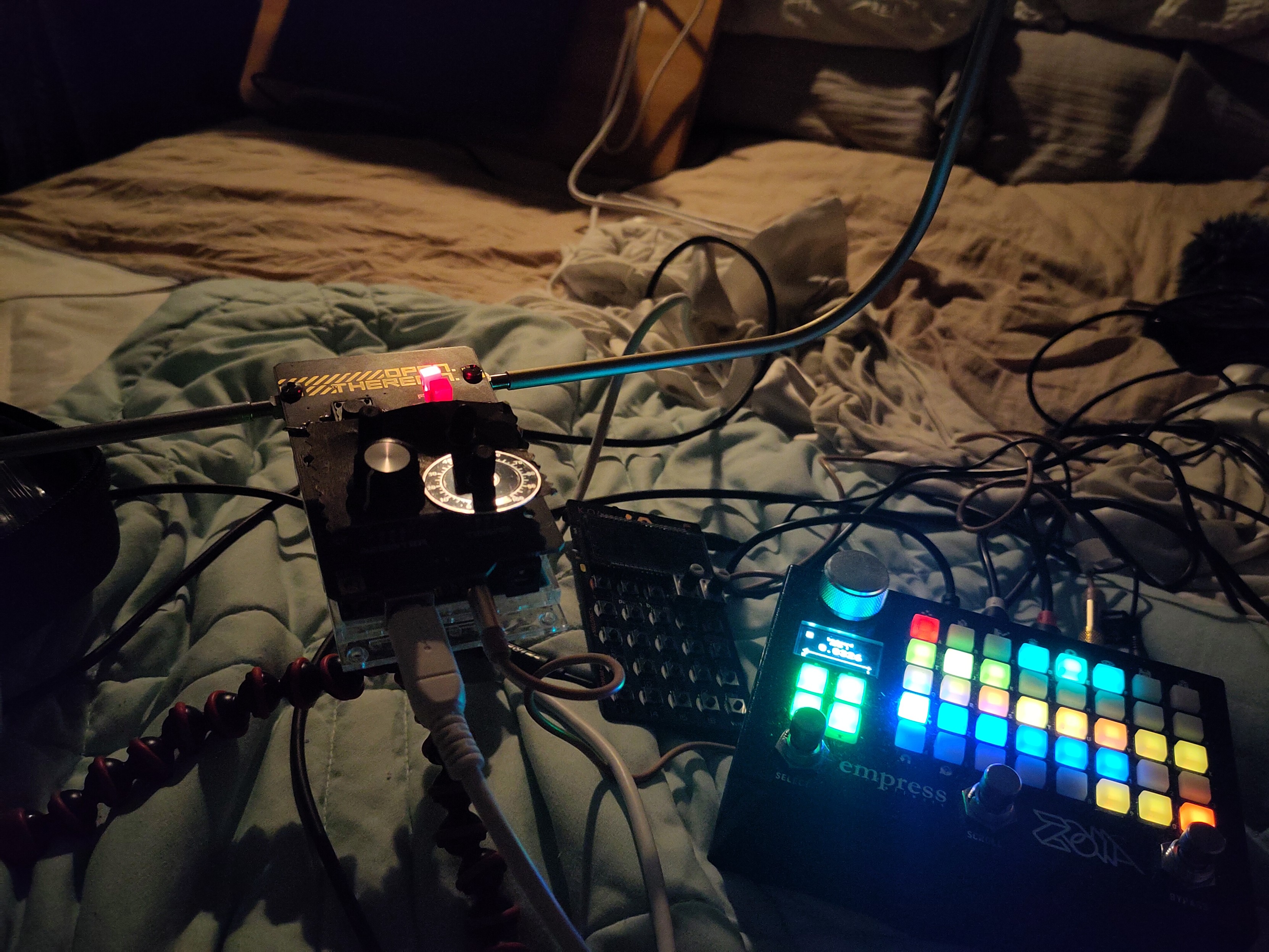 Empress ZOIA, Pocket operator, and Open Theremin on a pile of bedsheets and cables